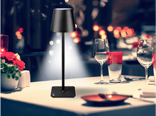 Charger l&#39;image dans la galerie, Lampe tactile noire sur une table. Verres à vin et une assiette rouge également sur la table dans une pièce.
