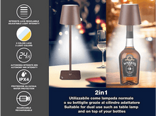 Charger l&#39;image dans la galerie, Une lampe est sur une table et sur une bouteille de whisky. Elle a une intensité lumineuse réglable, 3 couleurs et est rechargeable.
