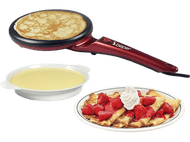 Crêpière avec une crêpe à l'intérieur. Un bol avec de la crème et une assiette avec des crêpes et des fraises.