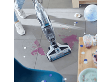 Charger l&#39;image dans la galerie, Une personne nettoie un sol avec un aspirateur humide. Des confettis éparpillés et du liquide renversé. Une ambiance de fête.
