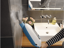 Charger l&#39;image dans la galerie, Une personne nettoie un mur de salle de bain avec un nettoyeur vapeur bleu et blanc, près d&#39;un lavabo et d&#39;un miroir.
