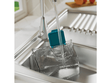 Charger l&#39;image dans la galerie, Un récipient transparent rempli d&#39;eau d&#39;un robinet dans un évier en acier inoxydable.
