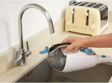 Charger l&#39;image dans la galerie, Une main remplit d&#39;eau un nettoyeur vapeur portatif dans un évier. Un grille-pain en arrière-plan.
