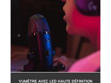 Charger l&#39;image dans la galerie, Un microphone noir avec une tête en mesh et une personne qui parle.
