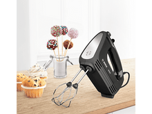 Charger l&#39;image dans la galerie, Mixeur à main noir sur une table en bois, avec des cupcakes et des cake pops en arrière-plan. Fond blanc.
