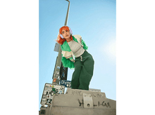 Charger l&#39;image dans la galerie, Une femme aux cheveux orange porte un casque, debout sur un panneau de signalisation, fond de ciel bleu.

