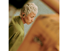 Charger l&#39;image dans la galerie, Homme blond avec des écouteurs regardant un téléphone.
