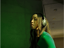 Charger l&#39;image dans la galerie, Femme portant un casque, chemise verte, fond vert.
