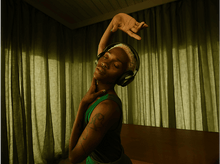 Charger l&#39;image dans la galerie, Une personne avec un casque et une robe verte. Elle danse, le bras en l&#39;air.
