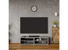 Charger l&#39;image dans la galerie, Salon avec TV sur support gris, horloge au mur et sol en bois.
