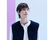 Charger l&#39;image dans la galerie, Un jeune homme portant un écouteur et un gilet noir, regardant sur le côté.
