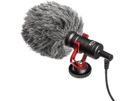 Un microphone noir avec une bonnette en fourrure et des accents rouges, sur fond noir.