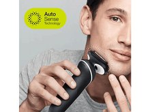 Charger l&#39;image dans la galerie, Un homme se rase avec un rasoir électrique noir et blanc, fond gris.
