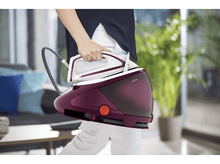 Charger l&#39;image dans la galerie, Personne tenant un fer à vapeur blanc et bordeaux. Le fond est flou.
