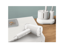 Charger l&#39;image dans la galerie, Un défroisseur à vêtements blanc est sur une table blanche.
