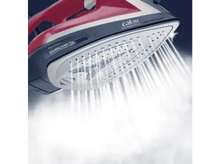 Charger l&#39;image dans la galerie, Un fer à repasser avec de la vapeur qui s&#39;échappe. Fer rouge et bleu avec semelle Durilium. Fond sombre et flou.
