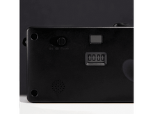 Charger l&#39;image dans la galerie, Gros plan d&#39;un appareil noir. Comprend un interrupteur, un affichage &#39;0000&#39;, un haut-parleur et un bouton. Le fond est sombre.
