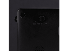 Charger l&#39;image dans la galerie, Gros plan sur l&#39;arrière d&#39;un appareil noir. Il comporte un bouton rond, un interrupteur avec les étiquettes OFF, ON, Flash et de petits trous.
