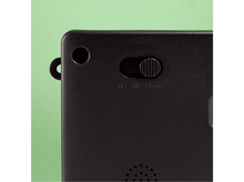 Charger l&#39;image dans la galerie, Gros plan d&#39;un appareil noir. Comprend un interrupteur marche/arrêt/flash, un petit trou et une boucle. Fond vert.
