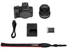 Charger l&#39;image dans la galerie, Une configuration d&#39;appareil photo avec l&#39;appareil photo, un objectif, un chargeur, une batterie, une sangle et d&#39;autres accessoires sur fond blanc.
