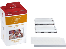 Charger l&#39;image dans la galerie, Une boîte d&#39;imprimante Canon rouge et blanche. Comprend une imprimante, de l&#39;encre et du papier. L&#39;art d&#39;un enfant est affiché.
