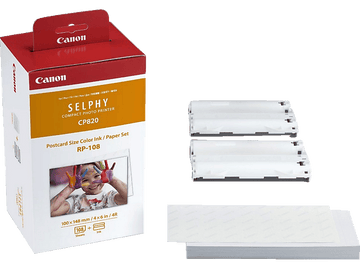 Une boîte d'imprimante Canon rouge et blanche. Comprend une imprimante, de l'encre et du papier. L'art d'un enfant est affiché.