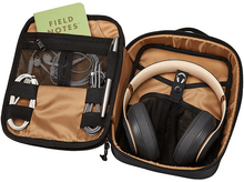 Charger l'image dans la galerie, Étui noir ouvert avec un casque, un carnet, un stylo et des câbles à l'intérieur.
