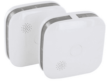 Charger l&#39;image dans la galerie, Deux détecteurs de fumée blancs. Forme carrée, ouvertures et un bouton. Fond blanc. Vue en angle.
