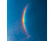 Arc-en-ciel traversant le ciel bleu. Croissant de lune. Étoiles en arrière-plan.