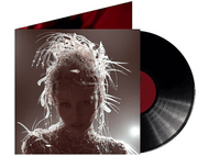 Femme avec coiffe ornée et détail du cou, à côté d'un disque vinyle et de la pochette de l'album. Fond rouge de la pochette.