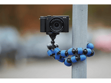 Charger l&#39;image dans la galerie, Un appareil photo noir est monté sur un trépied flexible fixé à un poteau métallique à l&#39;extérieur.
