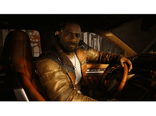 Charger l&#39;image dans la galerie, Un homme est assis dans une voiture, regardant devant lui. Il porte une veste en cuir.
