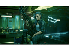 Charger l&#39;image dans la galerie, Une femme avec une arme est assise sur une table dans une pièce avec des enseignes au néon.
