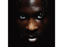 Charger l&#39;image dans la galerie, Gros plan sur un visage d&#39;homme, fond sombre, yeux bleu vif.
