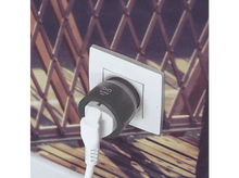 Charger l&#39;image dans la galerie, Adaptateur noir branché dans une prise murale blanche. Fond: structure en bois.
