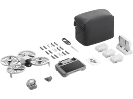 Kit de drone avec drone, télécommande, batteries, chargeur et accessoires, sur fond noir.