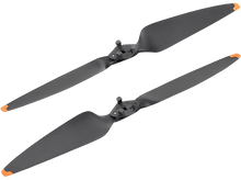 Charger l&#39;image dans la galerie, Deux hélices de drone noires avec des pointes oranges, sur fond noir.
