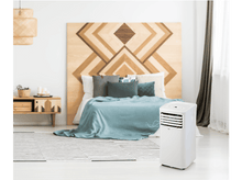 Charger l&#39;image dans la galerie, Une chambre avec un climatiseur blanc, un lit et une tête de lit en bois.
