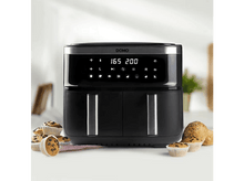 Charger l&#39;image dans la galerie, Friteuse à air noire avec affichage numérique, entourée de muffins et petits pains sur une table.
