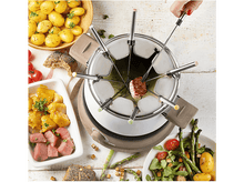 Charger l&#39;image dans la galerie, Un service à fondue avec divers aliments, dont de la viande, des légumes et du pain, disposés sur une table en bois.

