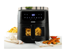 Charger l&#39;image dans la galerie, Friteuse à air noire avec des frites dans le panier. Frites, nuggets et sauce sur la table.
