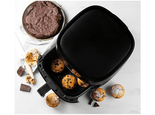 Charger l&#39;image dans la galerie, Une friteuse à air avec des muffins à l&#39;intérieur et un brownie sur le côté, avec des ingrédients sur une surface en marbre.
