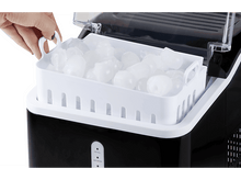 Charger l&#39;image dans la galerie, Une machine à glaçons avec un bac blanc rempli de glaçons. Une main retire le bac.
