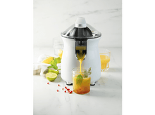 Charger l&#39;image dans la galerie, Presse-agrumes blanc, couvercle transparent, verse jus d&#39;orange dans verre à la menthe.
