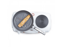 Charger l&#39;image dans la galerie, Une poêle avec du saumon et des oignons rouges sur une plaque de cuisson blanche.
