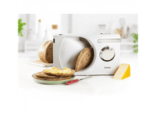 Charger l&#39;image dans la galerie, Trancheuse à pain blanche avec pain et fromage. La scène est sur une surface blanche.
