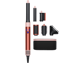 Ensemble de coiffure avec un outil de coiffure or rose et noir et divers accessoires. Fond noir.