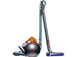 Aspirateur Dyson, argent et rouge. Corps arrondi, longue poignée et tuyau. Fond noir.