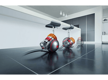 Charger l&#39;image dans la galerie, Trois aspirateurs Dyson sur un sol brillant dans une cuisine; deux tabourets derrière.
