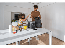 Charger l&#39;image dans la galerie, Homme et enfant préparant des articles, avec une centrale électrique sur une table.
